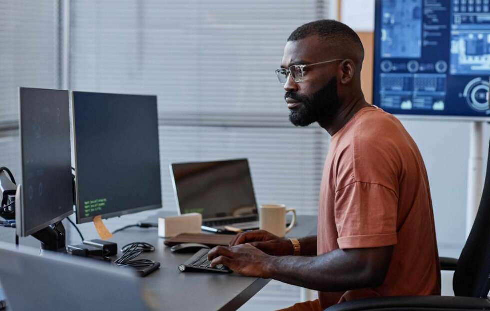 IT professional monitoring computer systems to help reduce IT downtime and improve business continuity.